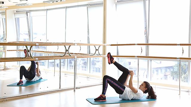 Photo of Gluteal bridge on one leg with dumbbell twisting exercise