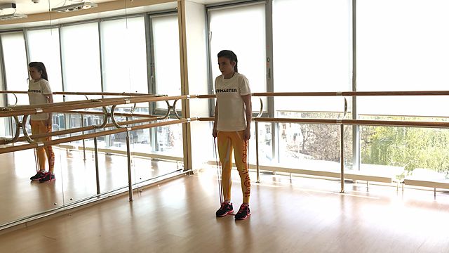 Photo of Standing Shrugs with a rubber band exercise