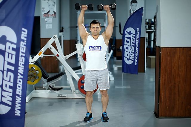 Photo of Standing Dumbbell Straight-Arm Front Delt Raise Above Head exercise