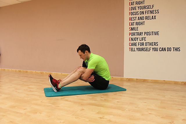 Фото упражнения Растяжка мышц обхватывая бедра в положении сидя