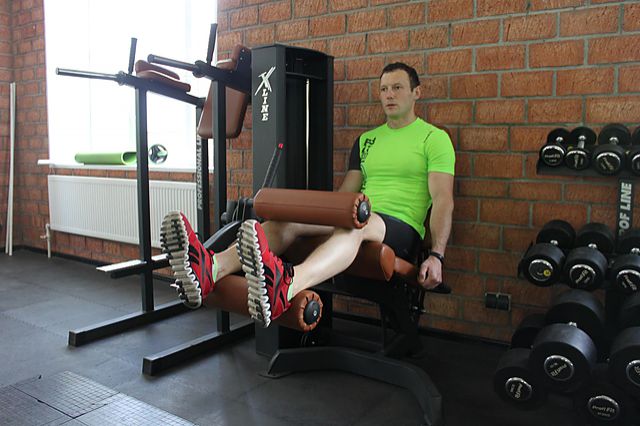 Фото упражнения Сгибание ног в тренажере сидя