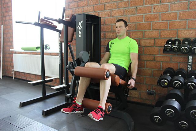 Фото упражнения Сгибание ног в тренажере сидя