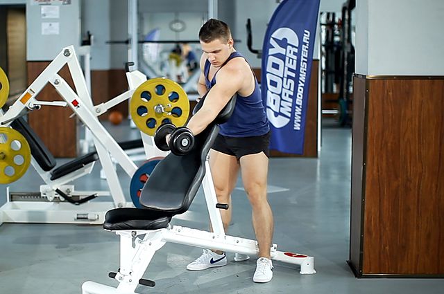 Photo of Standing One-Arm Dumbbell Curl Over Incline Bench  exercise